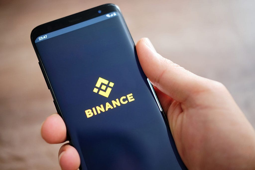 Binance logo with TORN, OMG, WAVES and USDC crypto tokens — featured image for article about Binance autoconverting assets to USDC